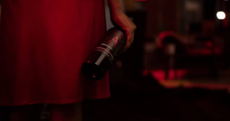 Red dress woman holding wine bottle