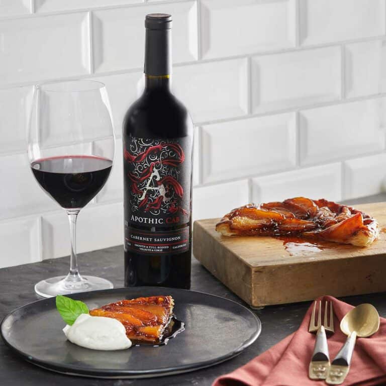 A gray plate with a tarte tatin in it in front of an Apothic Cab bottle