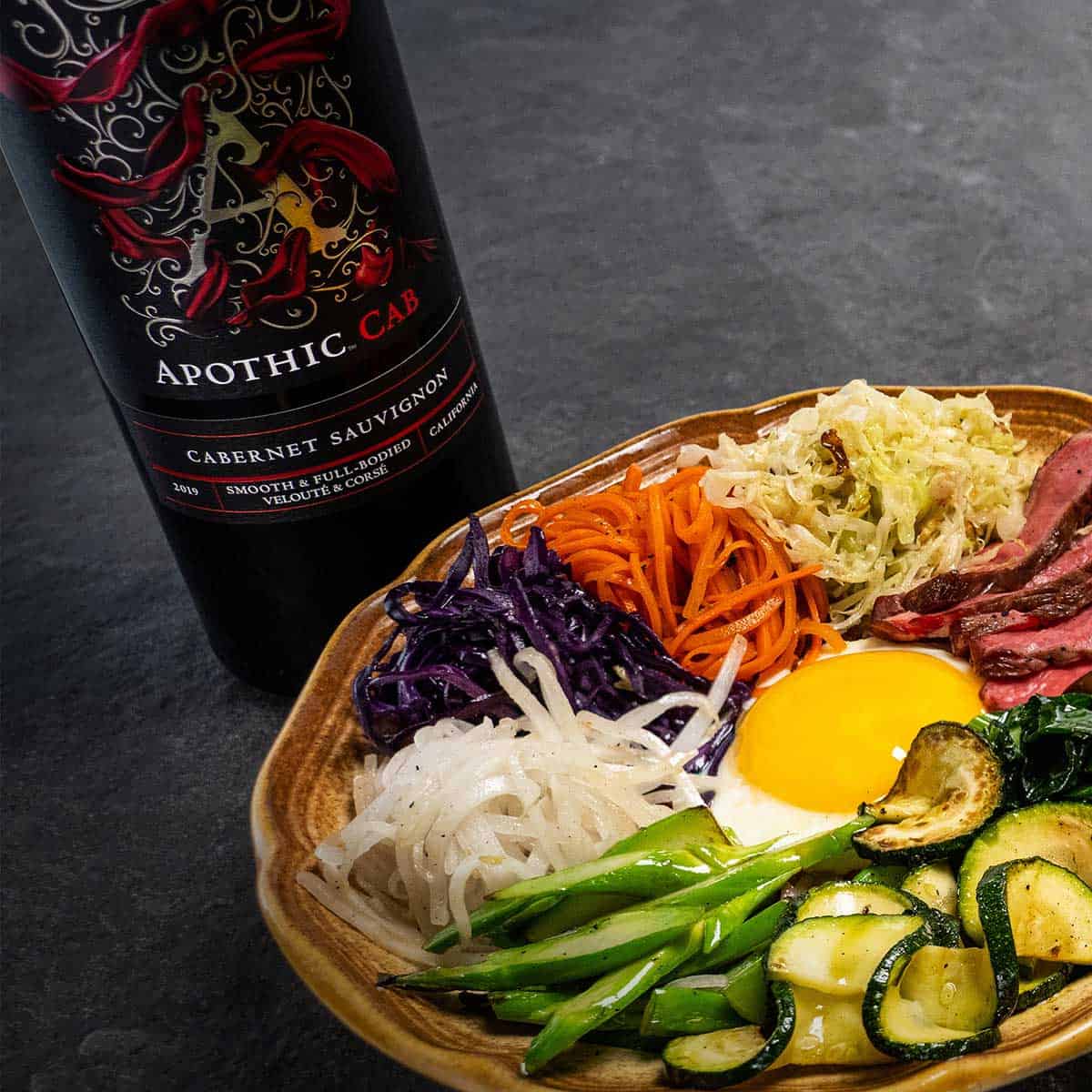 Plat de Bibimbap avec bouteille d'Apothic Cab.