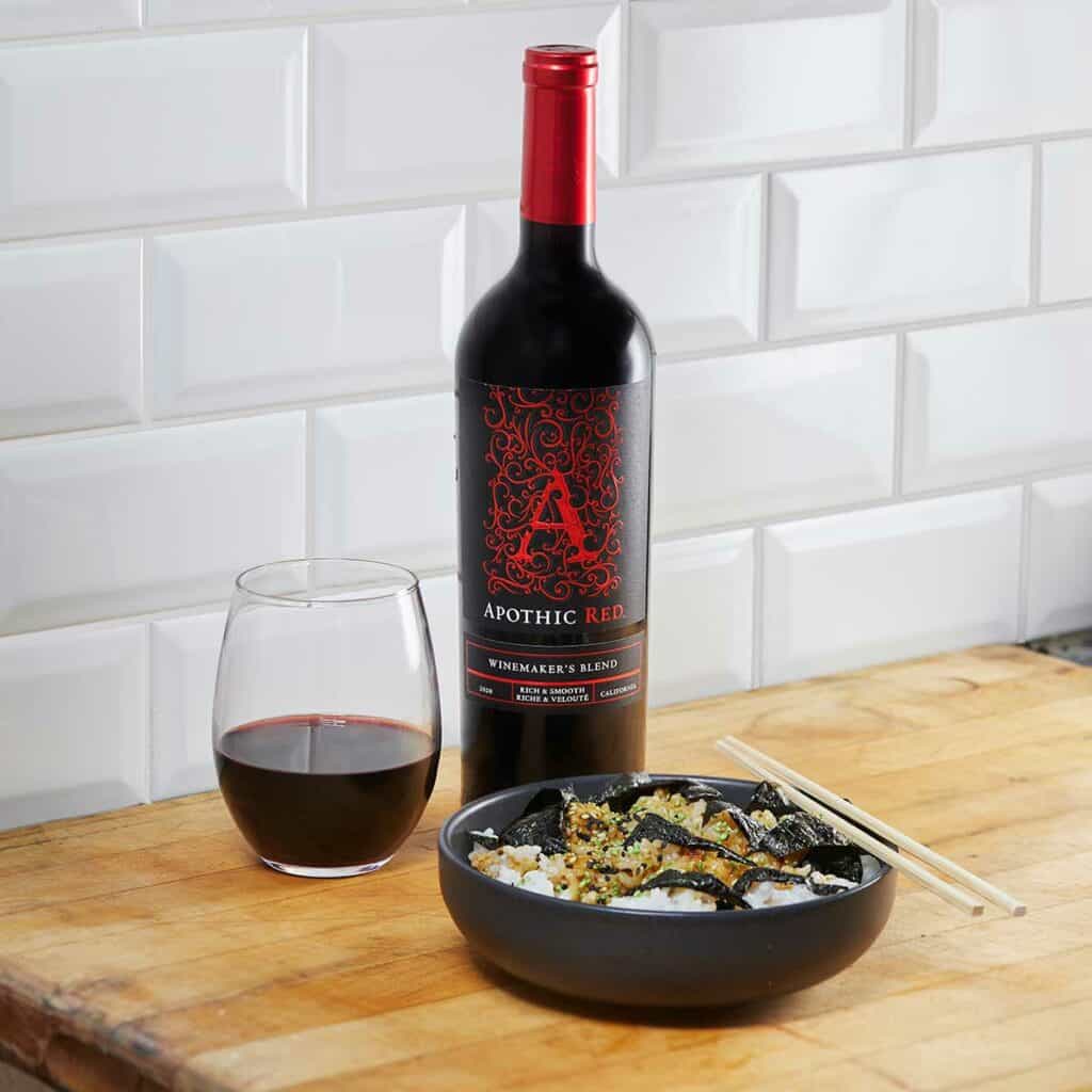 A rice bowl medley in front of a glass and a bottle of Apothic Red
