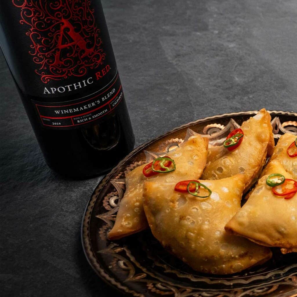 Plate of samosas and a bottle of Apothic red