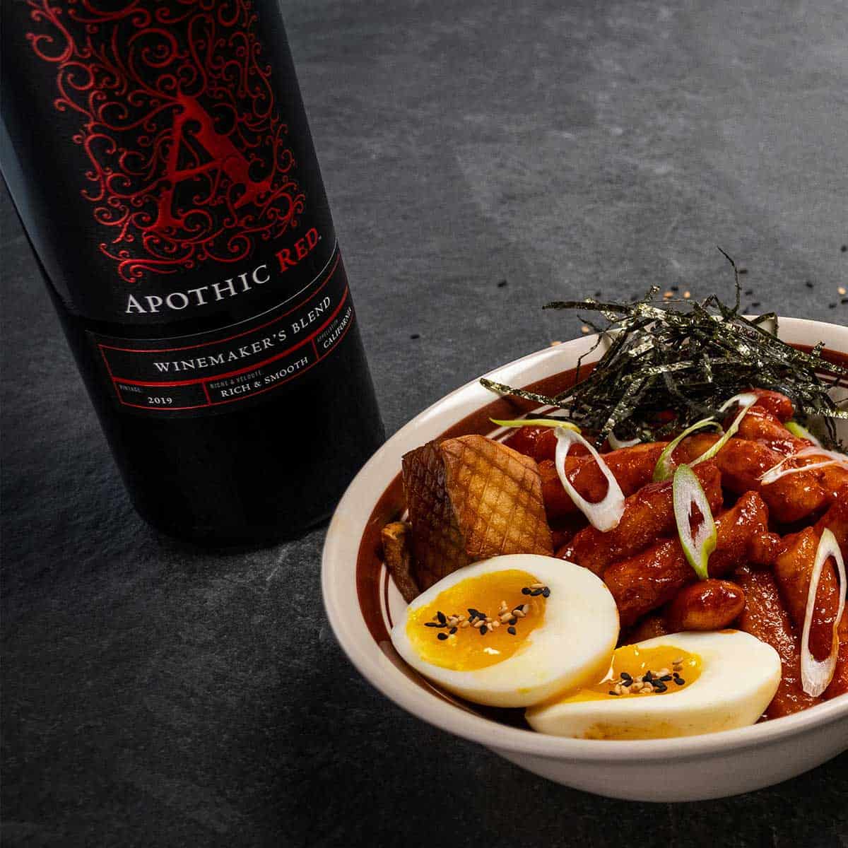 Bol de Tteokbokki avec vin rouge Apothic.